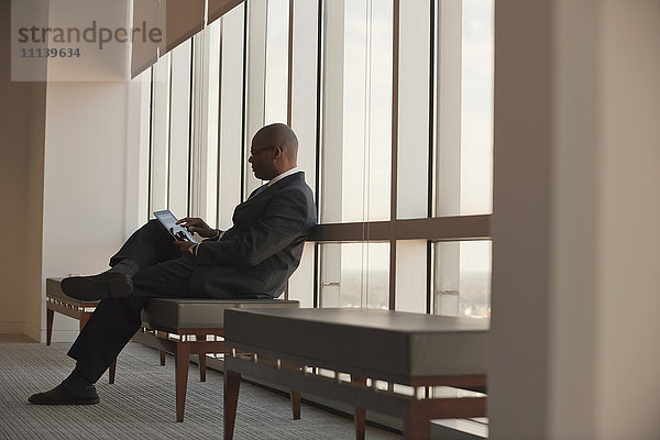 Afroamerikanischer Geschäftsmann benutzt digitales Tablet