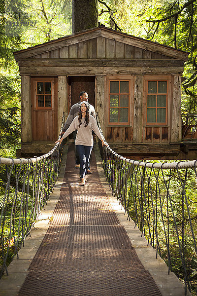 Ehepaar auf dem Gehweg eines abgelegenen Baumhauses