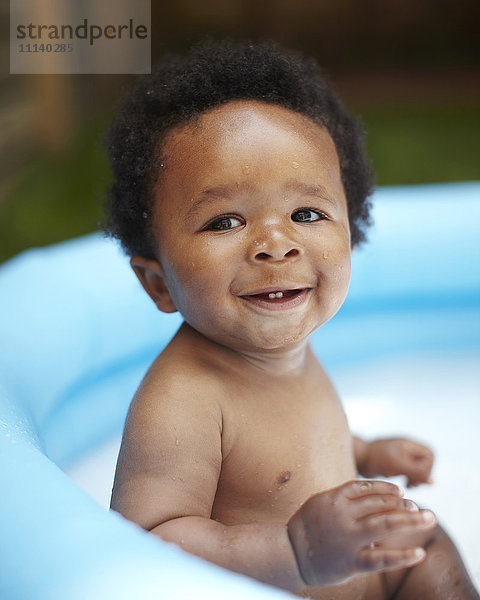 Lächelndes afroamerikanisches Baby im Schwimmbad