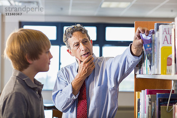 Lehrerin und Schülerin arbeiten in der Bibliothek