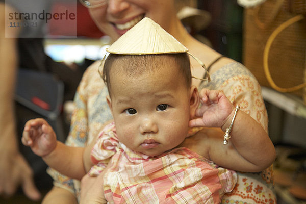 Baby Mädchen trägt asiatischen Hut