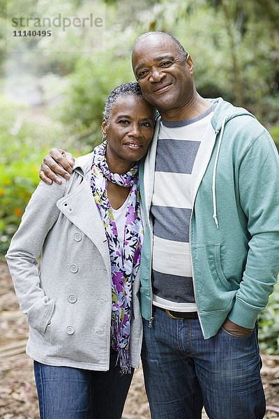 Lächelndes afroamerikanisches Paar  das sich im Park umarmt