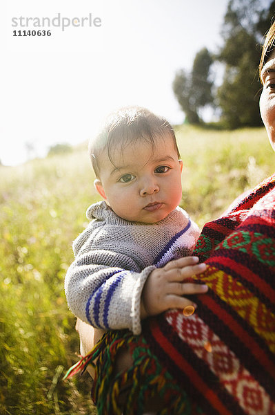 Mutter hält Baby im Feld