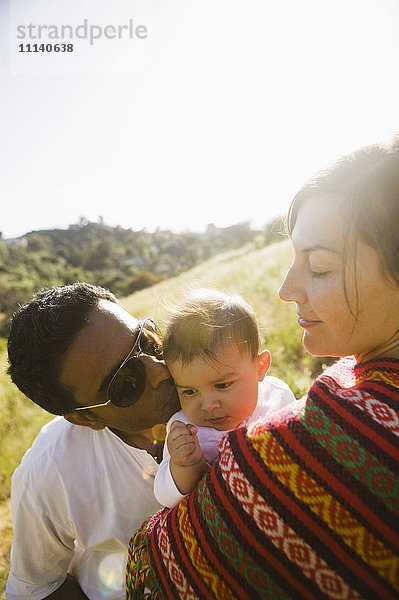 Mutter beobachtet Vater küsst Baby