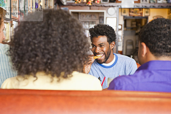 Lächelnde Freunde essen in einem Diner-Stand