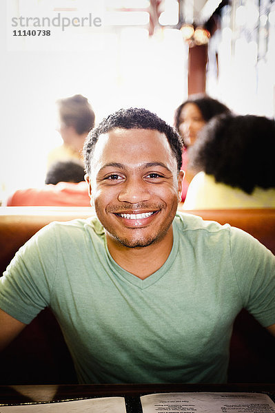 Lächelnder Mann gemischter Rasse in einem Diner