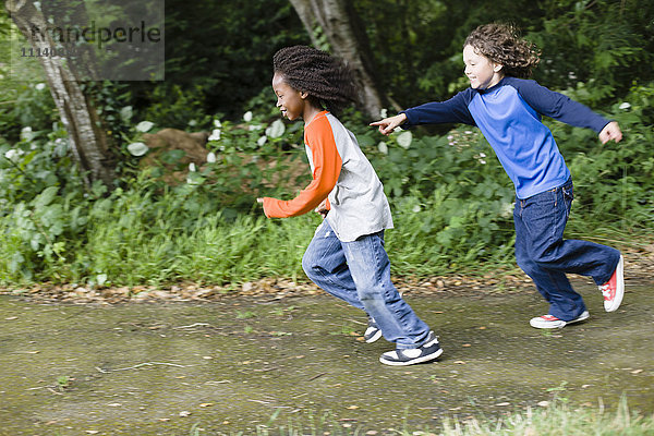 Jungen spielen Fangen im Park