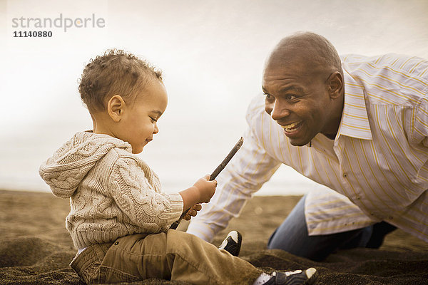 Vater und Sohn spielen am Strand