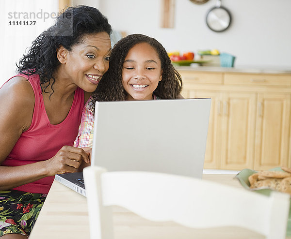 Mutter und Tochter schauen auf den Laptop