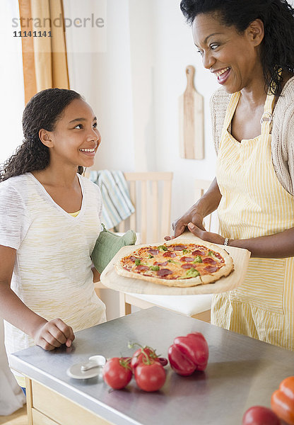 Mutter und Tochter bereiten Pizza zum Abendessen vor