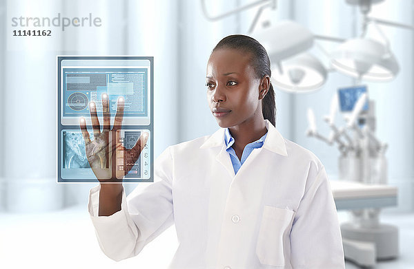 Afroamerikanischer Arzt schaut auf eine digitale Anzeige in einer Arztpraxis