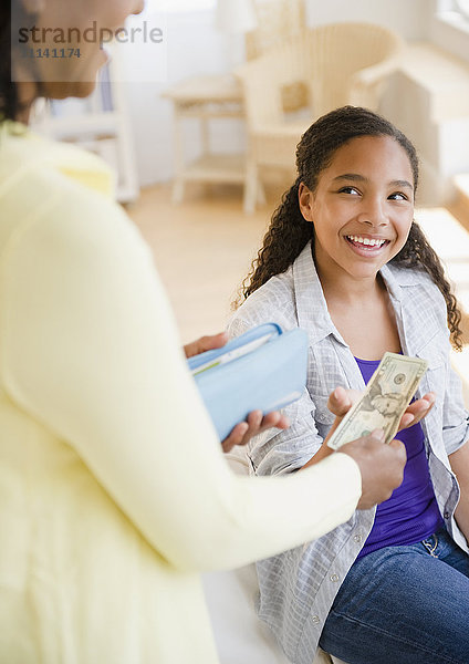 Mutter übergibt Geld an Tochter