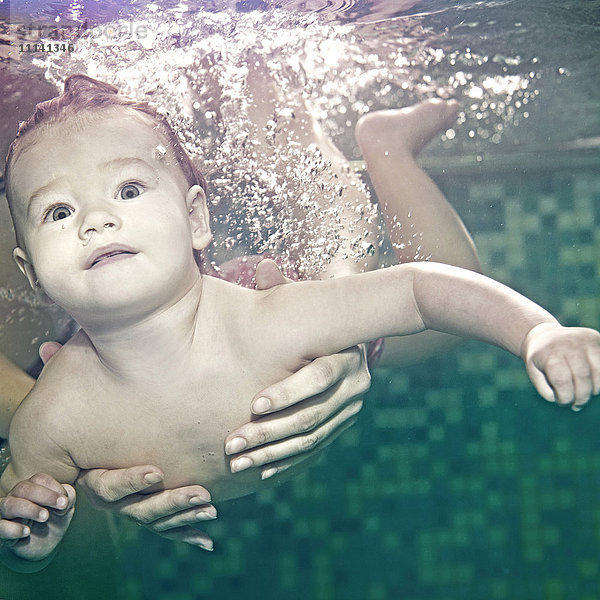 Kaukasisches Baby schwimmt unter Wasser