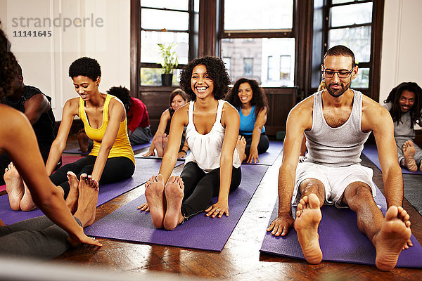 Menschen  die Yoga im Unterricht praktizieren