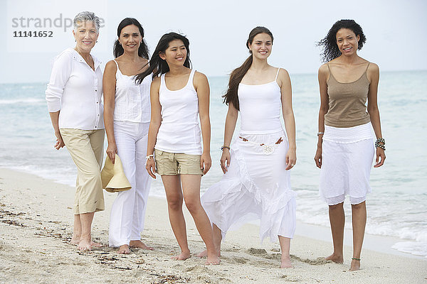 Unterschiedliche Frauen stehen gemeinsam am Strand