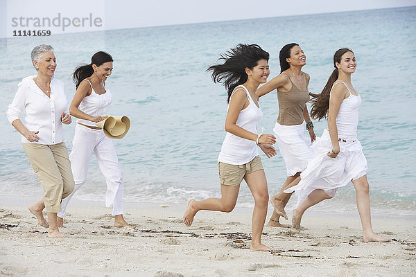 Unterschiedliche Frauen laufen gemeinsam am Strand