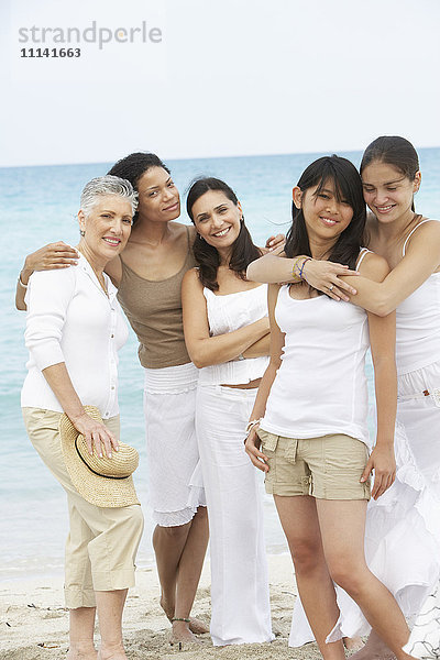 Unterschiedliche Frauen stehen gemeinsam am Strand