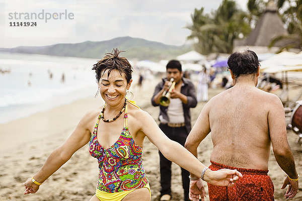 Hispanische Menschen genießen die Musik am Strand