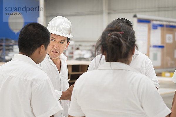 Arbeiter sprechen in einer Produktionsstätte