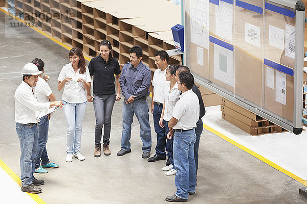 Arbeiter sprechen in einer Produktionsstätte
