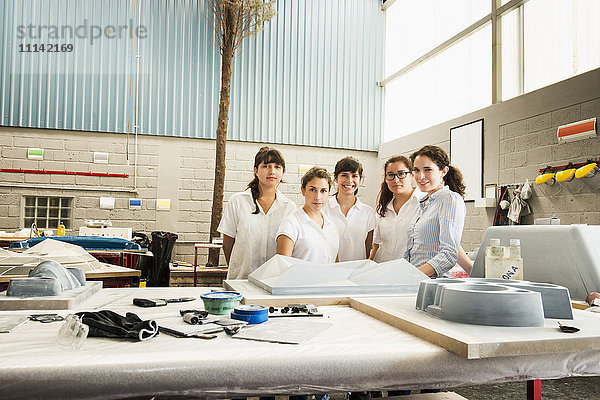 Lächelnde Arbeiter in einer Produktionsstätte