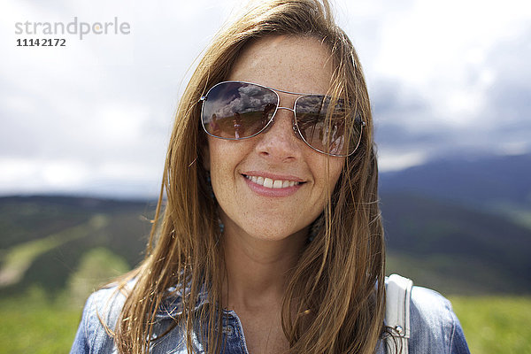 Lächelnde Frau mit Sonnenbrille im Freien