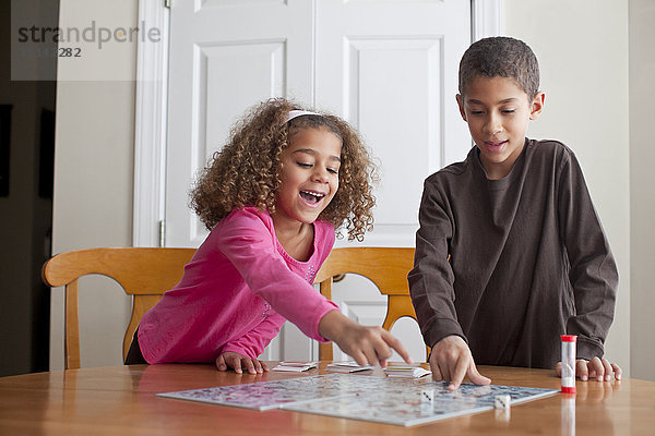 Gemischtrassige Kinder spielen zusammen ein Brettspiel