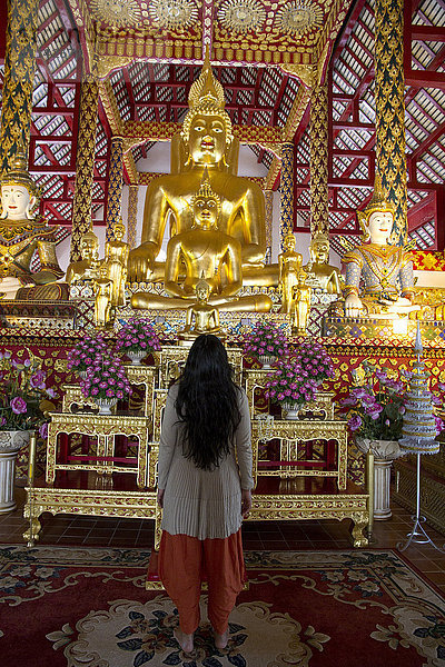 Frau bewundert Buddha-Statue im Tempel