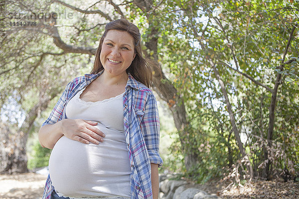 Schwangere kaukasische Frau im Park stehend
