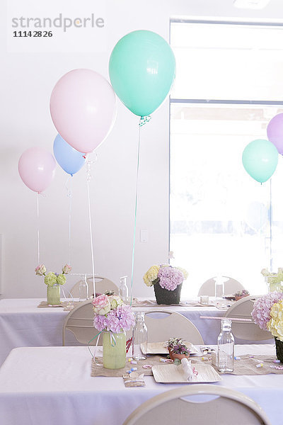 Gedecke auf Partytischen unter Luftballons