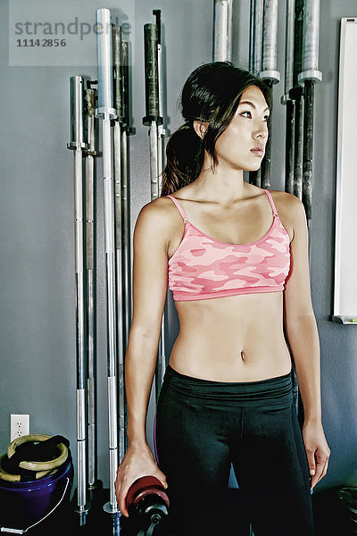 Asiatische Frau trainiert im Fitnessstudio