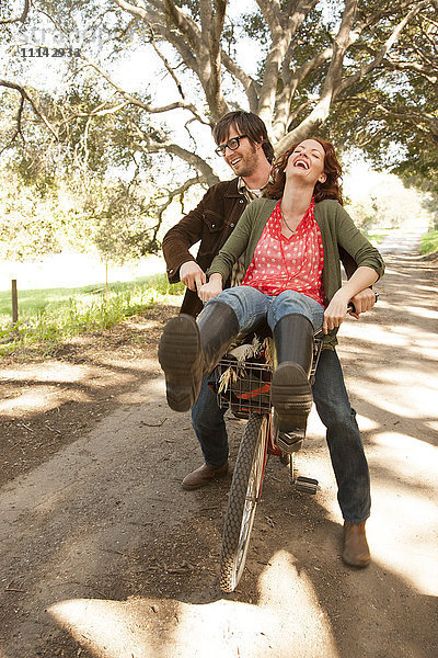 Paar fährt Fahrrad auf einer Landstraße