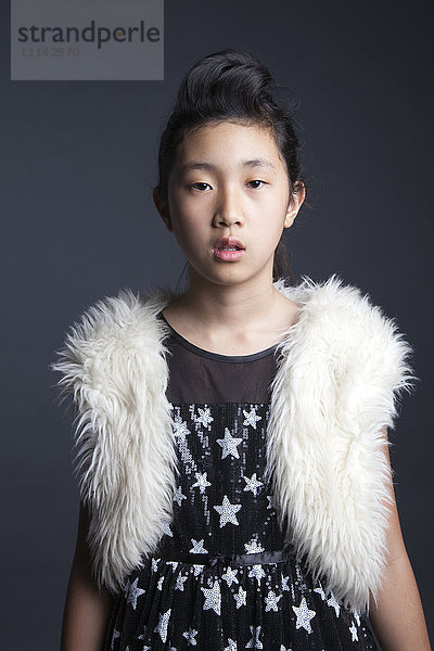 Seriöses asiatisches Mädchen trägt pelzige Weste