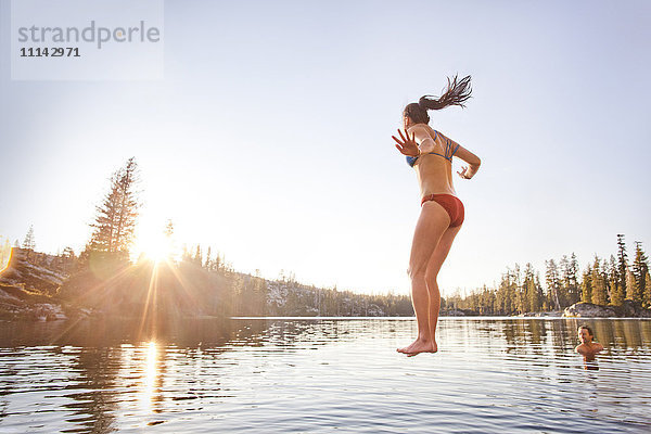 Frau springt in ländlichen See