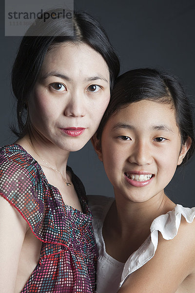 Asiatische Mutter und Tochter umarmen sich