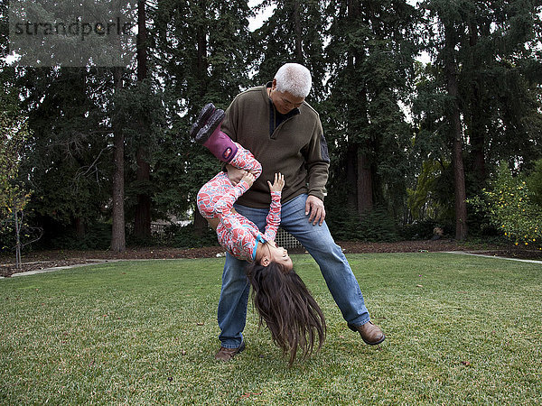 Vater und Tochter spielen im Hinterhof