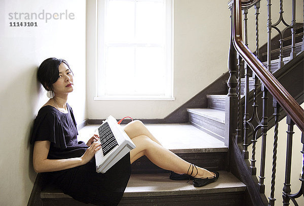 Taiwanesische Frau spielt Keyboard auf einer Treppe