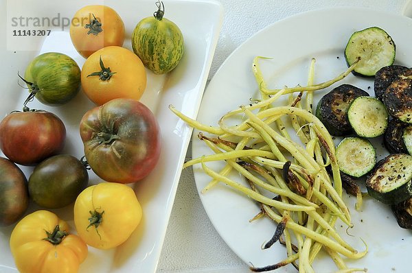 Teller mit frischen Tomaten und gegrilltem Gemüse