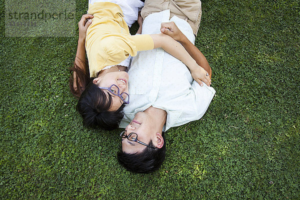 Asiatisches Paar umarmt auf Gras