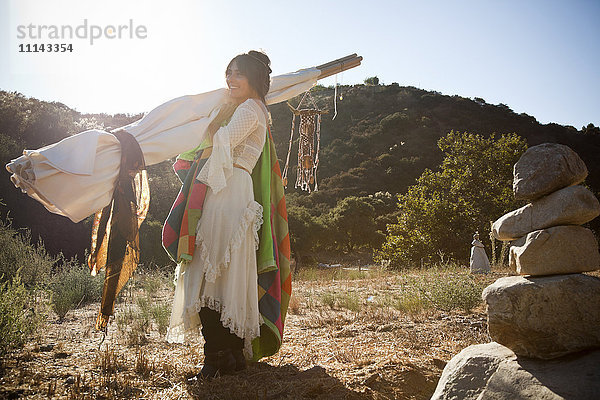 Hispanische Frau mit Tipi in der Wüste