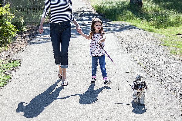 Mutter und Tochter gehen mit ihrem Welpen spazieren