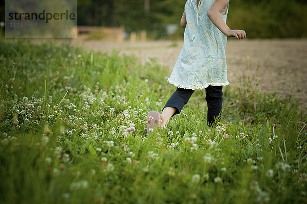Mädchen geht in einem Blumenfeld