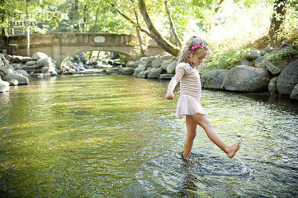 Mädchen planscht im Park Fluss