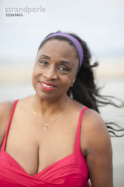 Schwarze Frau im Badeanzug am Strand