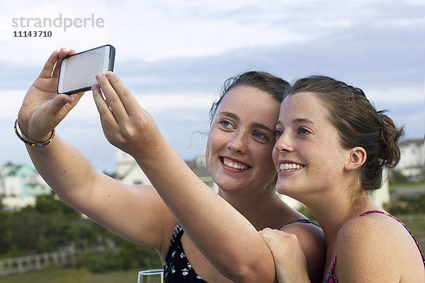 Kaukasische Frauen machen Selfie mit Handy