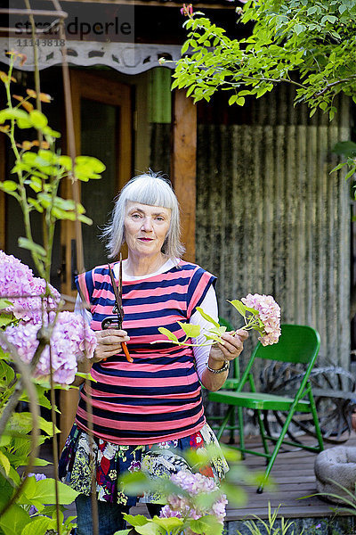 Ältere kaukasische Frau bei der Gartenarbeit im Hinterhof
