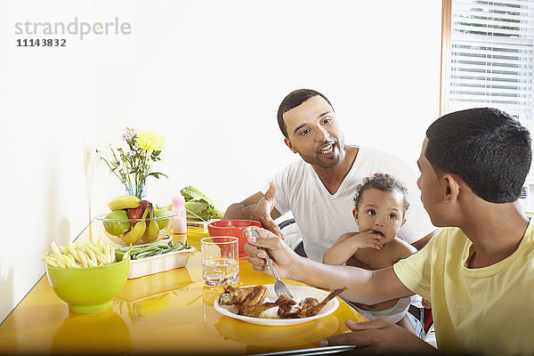 Hispanischer Vater und Kinder beim gemeinsamen Essen