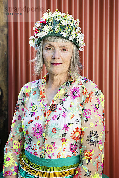Stilvolle ältere kaukasische Frau mit geblümter Kappe