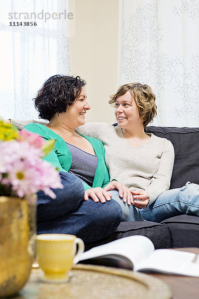 Lesbisches Paar entspannt sich auf dem Sofa im Wohnzimmer