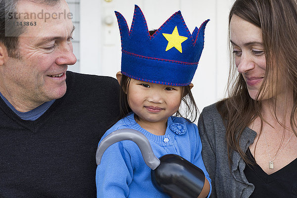 Eltern halten Tochter mit Haken und Krone